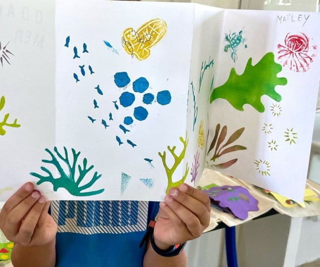 Enfant montrant sa réalisation créative